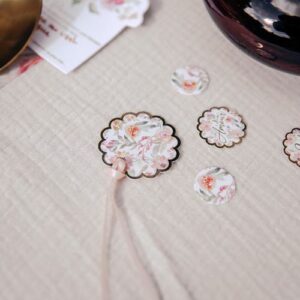 étiquettes Dahlia en papier blanc avec des couleurs pastel dorés, mesurant 4 cm de diamètre et accompagnées d’un ruban satin pêche
